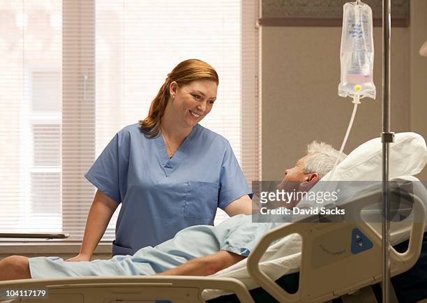 female nurse with male patient in hospital - iv drip stockfoto's en -beelden