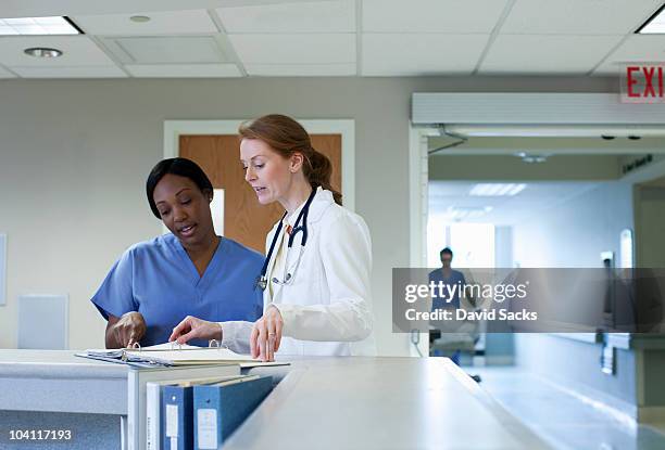 female doctor and nurse having discussion - healthcare professional stock pictures, royalty-free photos & images