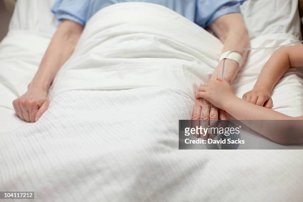 young girl holding grandma's hand in hospital - doença - fotografias e filmes do acervo