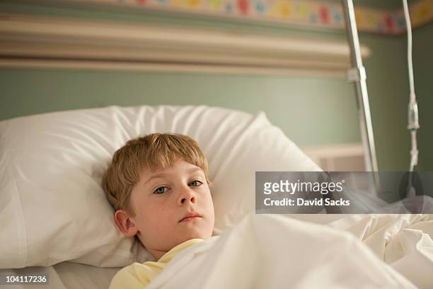 young boy lying in hospital bed - child hospital stock-fotos und bilder
