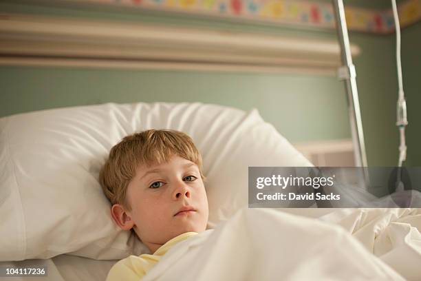 young boy lying in hospital bed - sick kid stock pictures, royalty-free photos & images