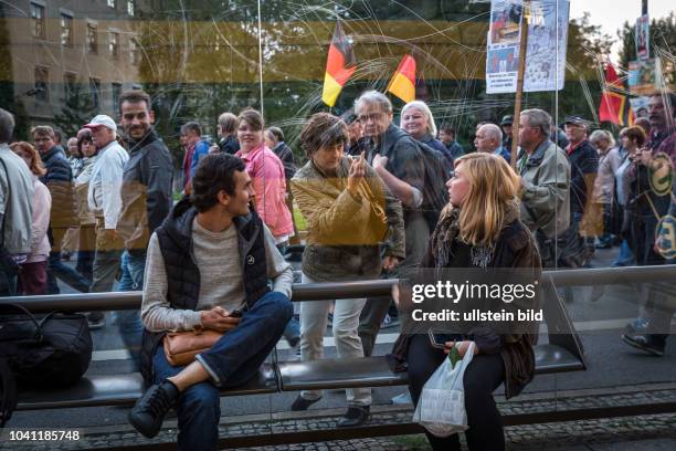 Germany Deutschland Dresden Pegida Demonstration in der Innenstadt.Frau der Demo zeigt einer Frau an einer Strassenbahnhaltestelle den Mittelfinger.