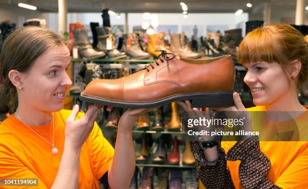 Saleswomen José Wessels and Eva Kemper look at custom-made size 60 shoes in a shoe store in Vreden, Germany, 29 September 2015. Shoemaker Georg...