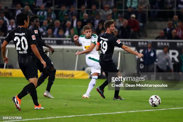 Thorgan Hazard of Borussia Monchengladbach scores his team's second goal past David Abraham of Eintracht Frankfurt during the Bundesliga match...