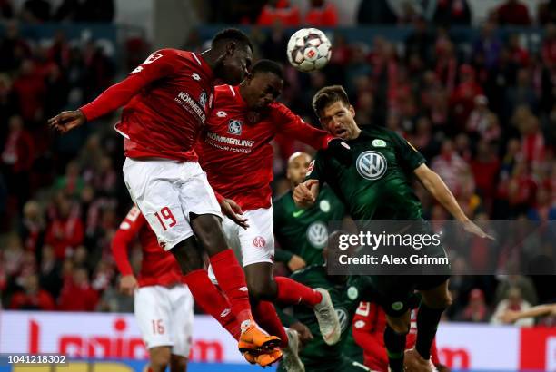 Moussa Niakhate, Jean Philippe Mateta of Mainz and Ignacio Camacho of Wolfsburg head for the ball during the Bundesliga match between 1. FSV Mainz 05...