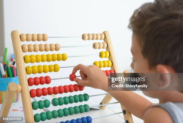 muchacho hermoso que aprender matemáticas con el ábaco - abaco fotografías e imágenes de stock