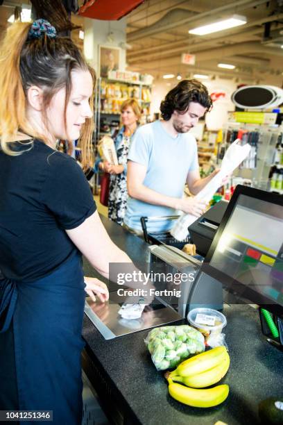 at the checkout in a supermarket - supermarket queue stock pictures, royalty-free photos & images