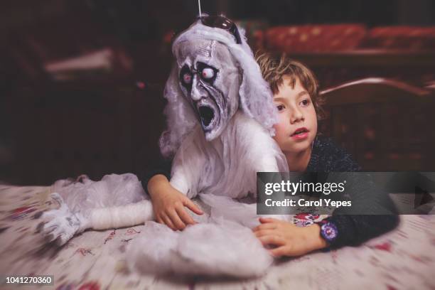 boy hugging a ghost during halloween party - october holiday stock pictures, royalty-free photos & images