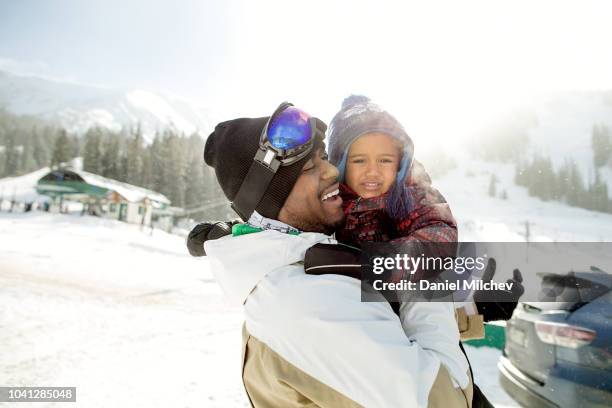 happy multi-ethnic father and son at a ski resort getting ready to go skiing. - family skiing bildbanksfoton och bilder