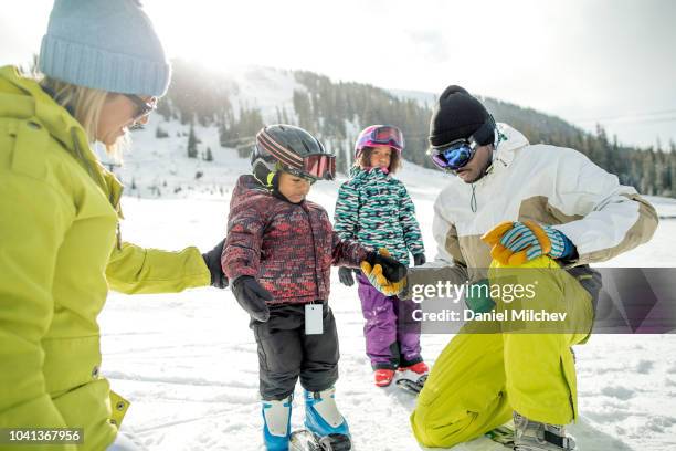 mixed race family teaching their young boy to ski at a winter ski resort in colorado. - keystone stock pictures, royalty-free photos & images