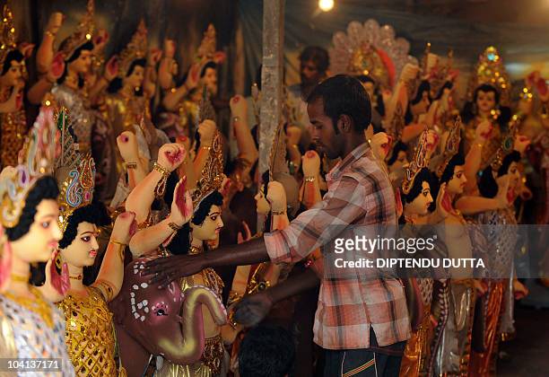An Indian artist adds the final touches to an idol of the Hindu god Biswakarma in Siliguri on September 16, 2010. Biswakarma is the Hindu god of...