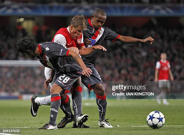 Arsenal's Russian player Andrey Arshavin vies with Sporting Braga's Portuguese player Silvio and Sporting Braga's Peruvian player Alberto Rodriguez...