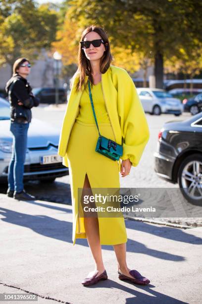Gala Gonzales, wearing a neon yellow top and skirt, a matching neon yellow jacket, a green Rochas crossbody bag and snake print shoes, is seen before...
