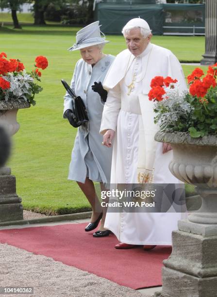 Queen Elizabeth II and Pope Benedict XVI walk through the gardens at the Palace of Holyroodhouse during day one of his four day state visit to the...