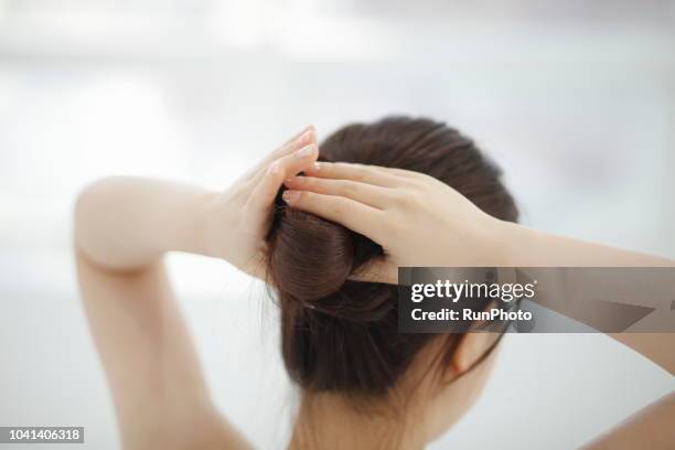 woman making hair bun - up do stock pictures, royalty-free photos & images