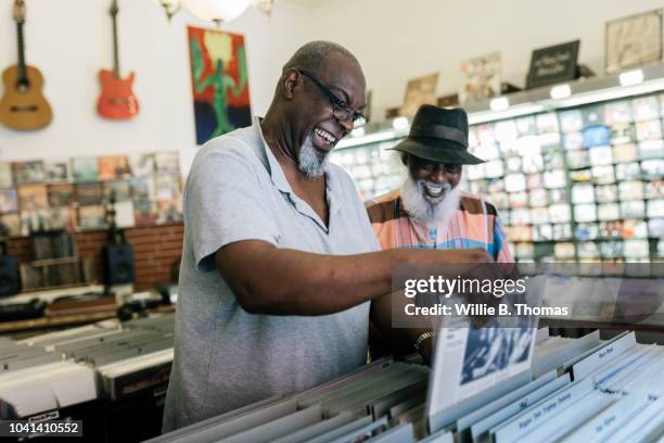 elderly black friends searching record bin - plattenladen stock-fotos und bilder