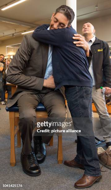 Sultan Koesen , the world's tallest person at 2.51 metres, and shoemaker Georg Wessels hug in a shoe store in Vreden, Germany, 29 September 2015....