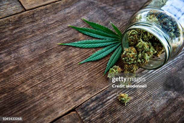 大麻芽從玻璃罐中傾瀉而出的木質背景 - legalization 個照片及圖片檔