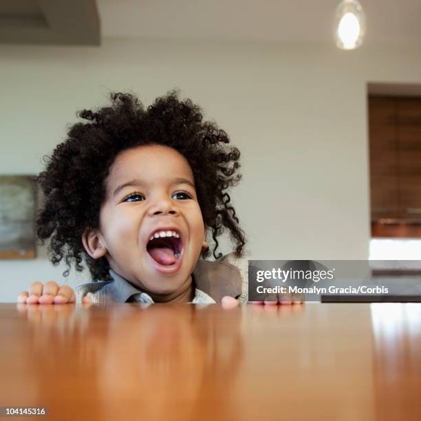 smiling boy looking over a table - cultura afro americana stock-fotos und bilder