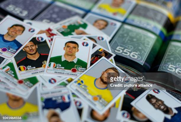 An illustration shows a pile of so-called Panini stickers of various European national soccer players on display on top of a EURO 2016 sticker album...