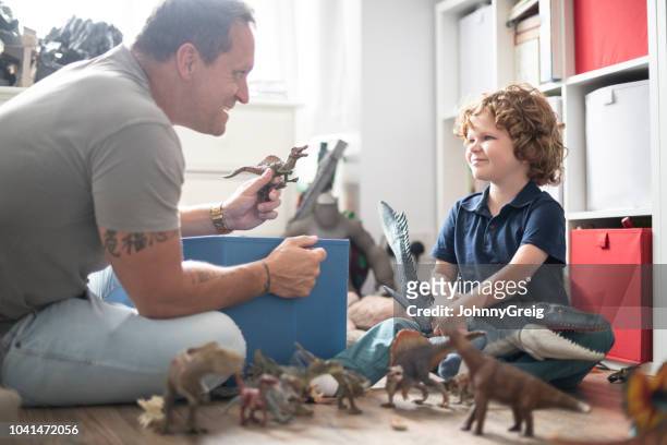 ragazzo che gioca con i giocattoli con suo padre - rappresentazione di animale foto e immagini stock