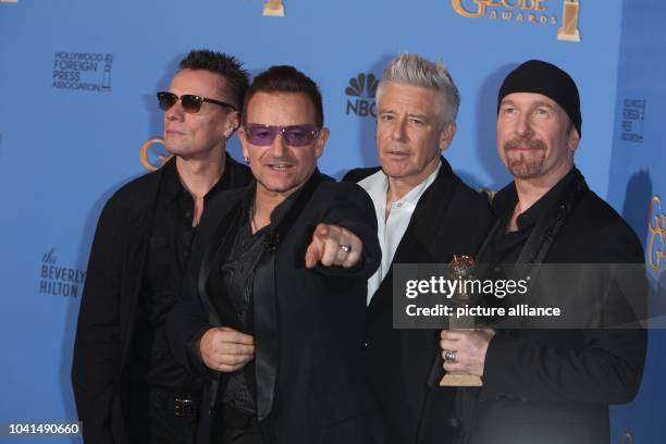 Larry Mullen Jr. , Bono, Adam Clayton and The Edge of U2 pose in the press room of the 71st Annual Golden Globe Awards aka Golden Globes at Hotel...