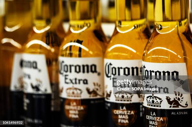 Detail of lined up Corona beer bottles seen on the store shelf. Corona extra Lager Beer is the flagship product of the Mexican company Grupo Modelo.