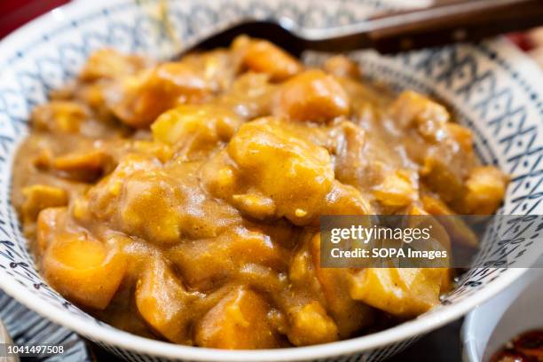 Japanese-style curry is displayed on top a wooden dining room table.