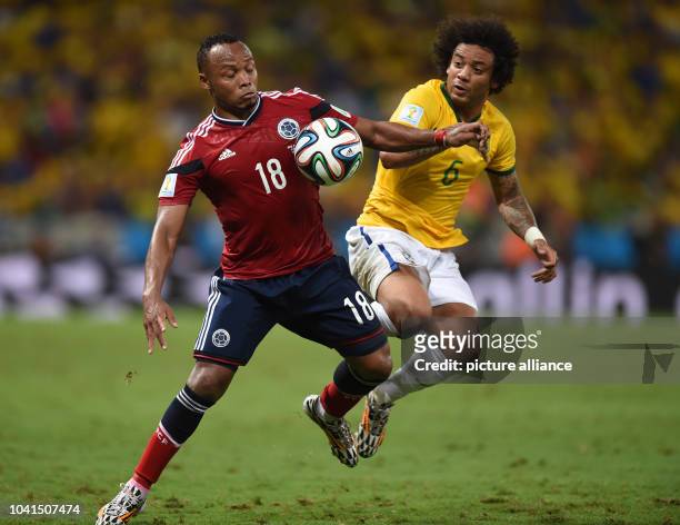Marcelo of Brazil and Juan Zuniga of Colombia vie for the ball during the FIFA World Cup 2014 quarter final match soccer between Brazil and Colombia...