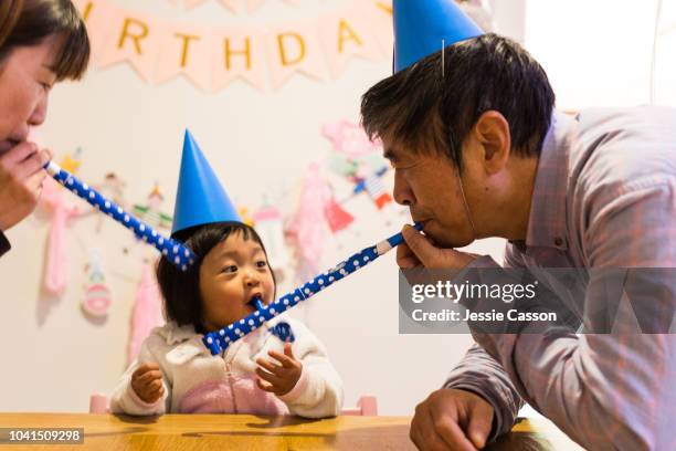 family blowing party horn blowers for child birthday celebration - chinese birthday stockfoto's en -beelden