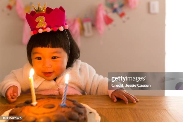 child about to blow the candles of her birthday cake - chinese birthday stockfoto's en -beelden