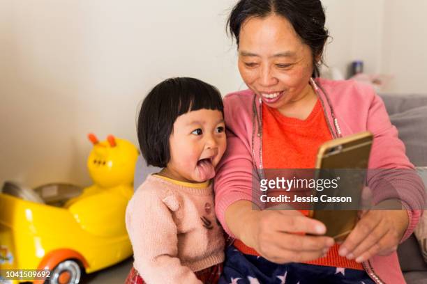 grandmother and granddaughter take a funny selfie - mamie grimace photos et images de collection