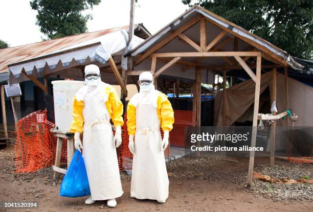 Two medical doctors wear protective suits at the ebola treatment centre in Gueckedou, Guinea, 16 October 2014. Former ebola patients, who are immune...