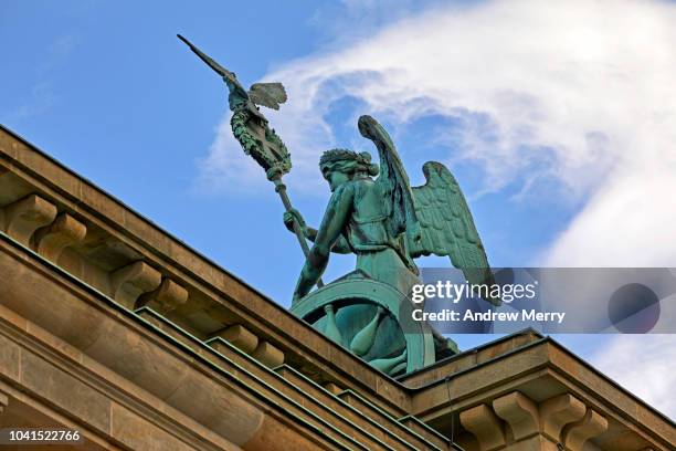 berlin quadriga, wings and chariot wheel with clouds and blue sky, brandenburg gate, germany - quadriga statue brandenburg gate stock-fotos und bilder