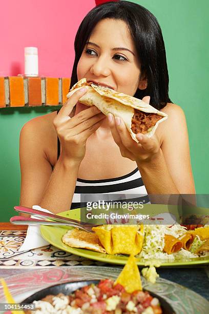 close-up of a young woman eating a wrap sandwich - female eating chili bildbanksfoton och bilder