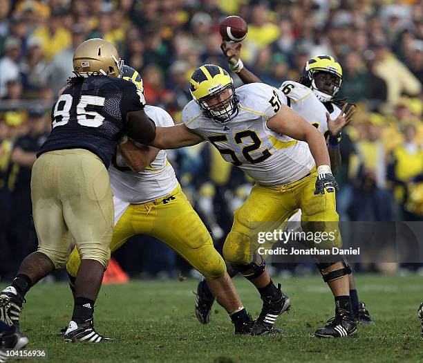 Stephen Schilling of the Michigan Wolverines blocks for quarterback Denard Robinson as Ian Williams of the Notre Dame Fighting Irish rushes at Notre...