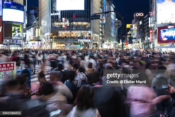 blurred motion on shibuya crossing in tokyo, japan - population growth stock pictures, royalty-free photos & images