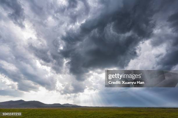 rays of light through storm clouds - gewitterwolke stock-fotos und bilder