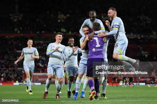 Derby players celebrate with Derby goalkeeper Scott Carson after his penalty save gifted them victory during the Carabao Cup Third Round match...