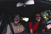 Two happy young women having fun in car