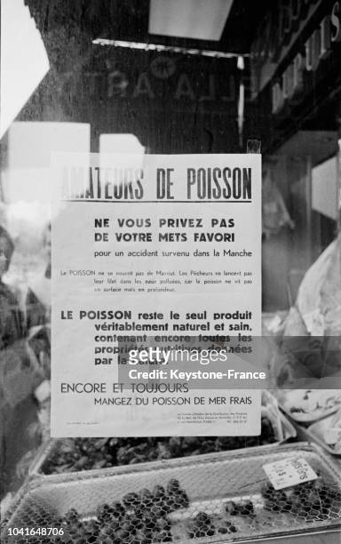 Une affiche indiquant aux clients que le poisson n'est pas souillé par la 'marée noire' est accroché sur la vitrine d'une poissonnerie à Paris,...