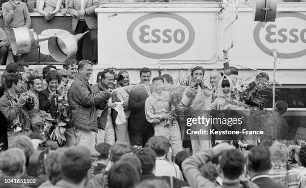 Les deux vainqueurs, Dan Gurney et AJ Foyt, arrosent leurs amis et admirateurs avec une bouteille de champagne, au Mans, France, le 12 juin 1967.