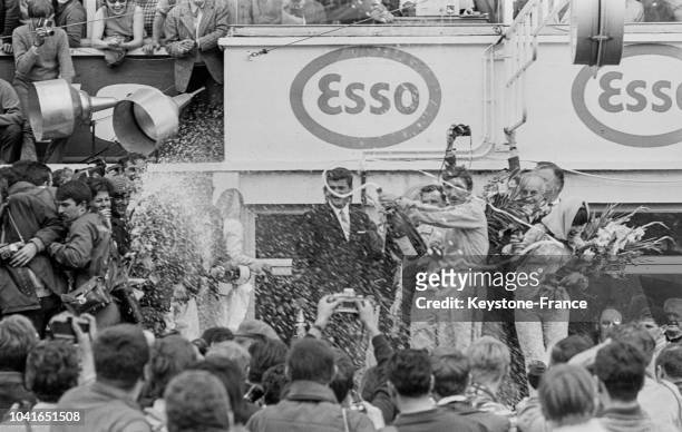 Les deux vainqueurs, Dan Gurney et AJ Foyt, arrosent leurs amis et admirateurs avec une bouteille de champagne, au Mans, France, le 12 juin 1967.