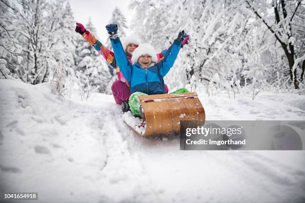 kids tobogganing on christmas - kids playing snow stock pictures, royalty-free photos & images