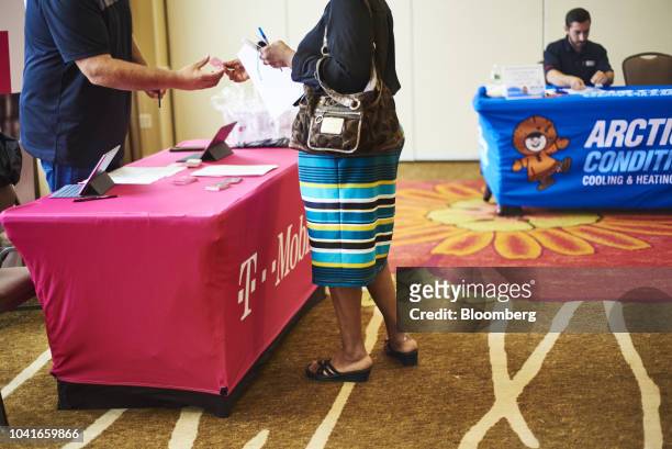 Job seekers speaks with a T-Mobile US Inc. Representative during a National Career Fair event in Edison, New Jersey, U.S., on Thursday, Sept. 20,...