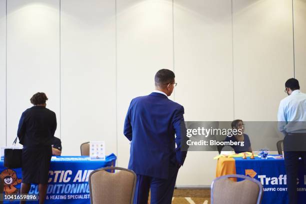 Job seekers speaks with representatives during a National Career Fair event in Edison, New Jersey, U.S., on Thursday, Sept. 20, 2018. Filings for...