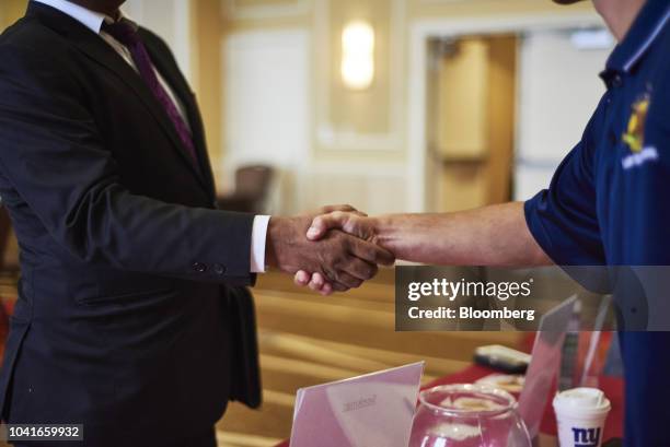 Job seeker shakes hands with a representative during a National Career Fair event in Edison, New Jersey, U.S., on Thursday, Sept. 20, 2018. Filings...