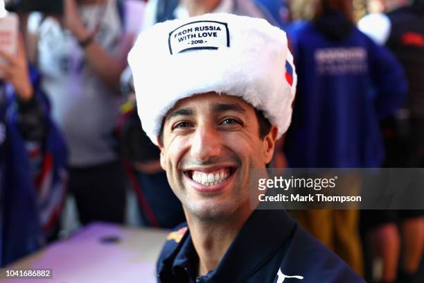 Daniel Ricciardo of Australia and Red Bull Racing smiles at the autograph signing session wearing a traditional Russian Ushanka hat during previews...
