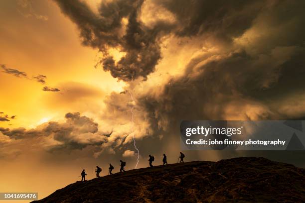 hikers on the storm at sunset, catbells mountain, lake district. uk. - stormy sky lightning stock pictures, royalty-free photos & images