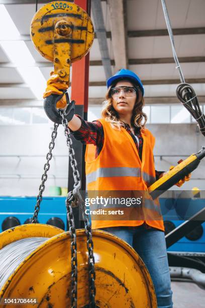 young engineer woman holding and working with remote control for operating crane - hoisting stock pictures, royalty-free photos & images